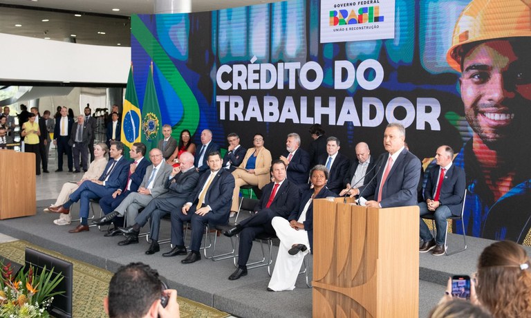 Imagem de um trabalhador feliz segurando dinheiro após aprovação do crédito